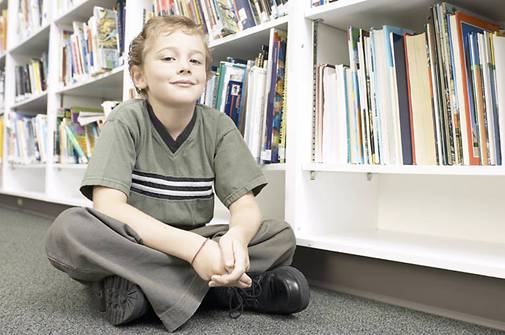 Little boy sitting in aisle of library 1.jpg