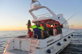 Happy fishermen with fish on Big Boat